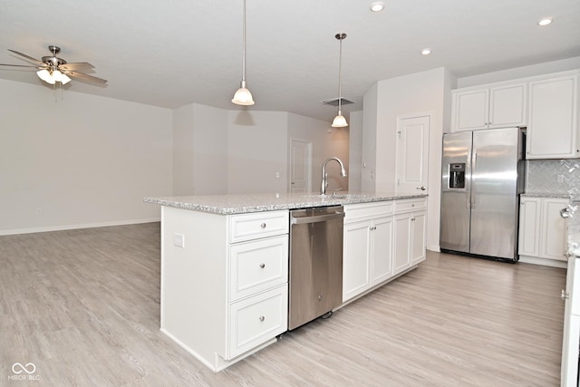 kitchen with a center island with sink, backsplash, light wood-style flooring, appliances with stainless steel finishes, and a sink