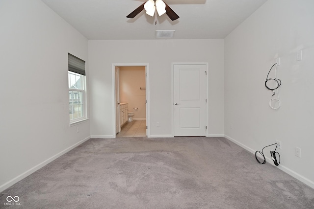 empty room featuring ceiling fan, carpet floors, visible vents, and baseboards