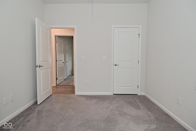 unfurnished bedroom with carpet floors and baseboards