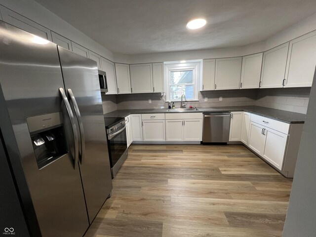 662 S County Road 150 W, Greensburg, IN 47240 - kitchen featuring stainless steel appliances, dark countertops, tasteful backsplash, and white cabinets