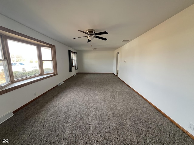 unfurnished room with carpet, visible vents, ceiling fan, and baseboards