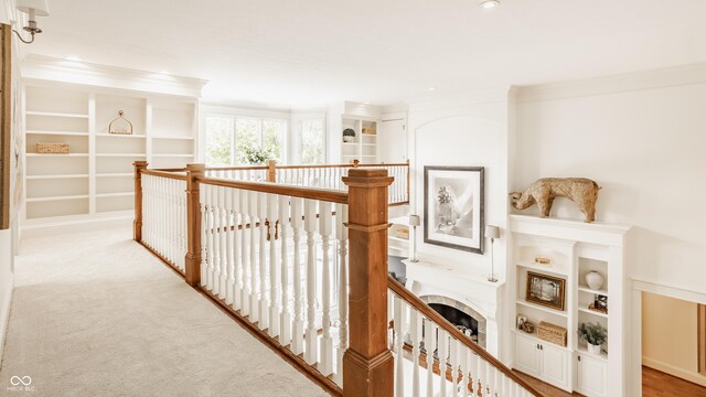 6560 Dawson Lake Dr, Indianapolis, IN 46220 - hallway featuring crown molding, an upstairs landing, built in shelves, and light carpet