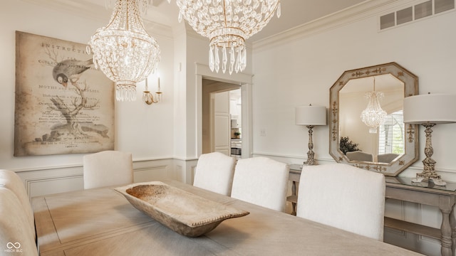 6560 Dawson Lake Dr, Indianapolis, IN 46220 - dining space featuring a chandelier, crown molding, wainscoting, and a decorative wall