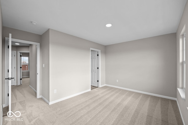 empty room with light carpet, recessed lighting, and baseboards