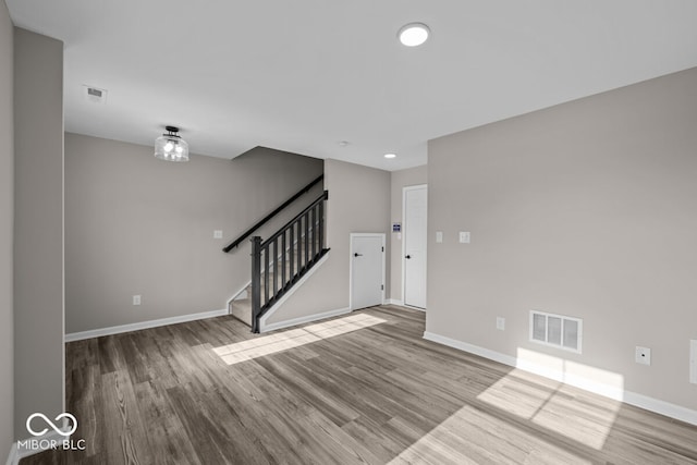 interior space with visible vents, stairway, baseboards, and wood finished floors