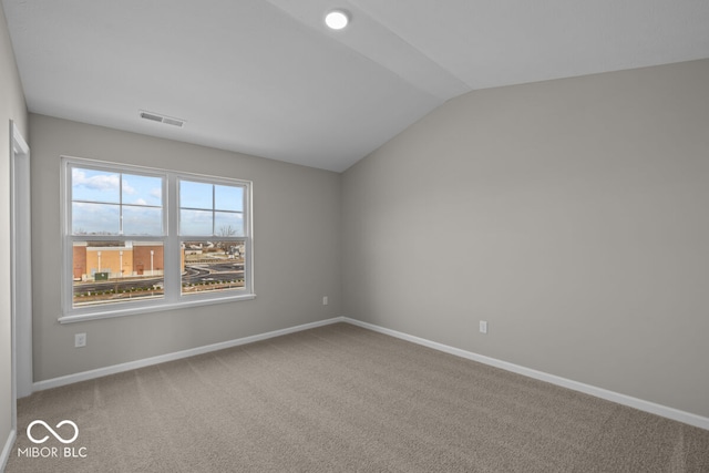 unfurnished room featuring lofted ceiling, carpet flooring, visible vents, and baseboards