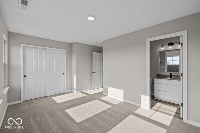 unfurnished bedroom with baseboards, visible vents, a sink, and light colored carpet