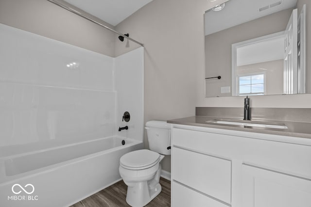 full bath featuring shower / washtub combination, visible vents, toilet, vanity, and wood finished floors