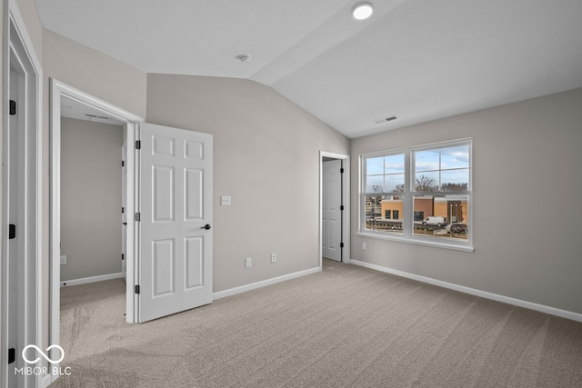 unfurnished bedroom featuring lofted ceiling, baseboards, visible vents, and carpet