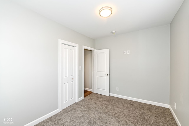 carpeted spare room featuring baseboards