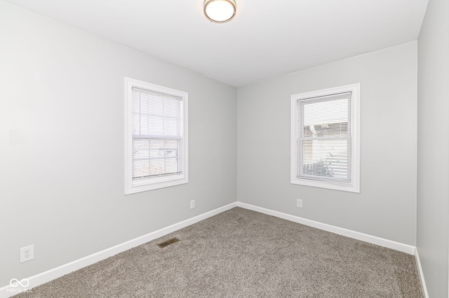 spare room with visible vents, baseboards, and carpet