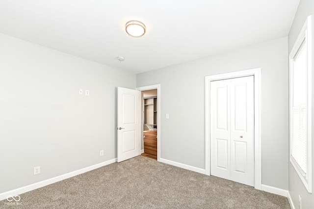 unfurnished bedroom featuring a closet, baseboards, and carpet flooring