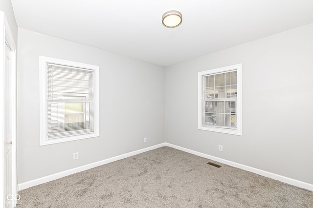 unfurnished room with baseboards and carpet flooring