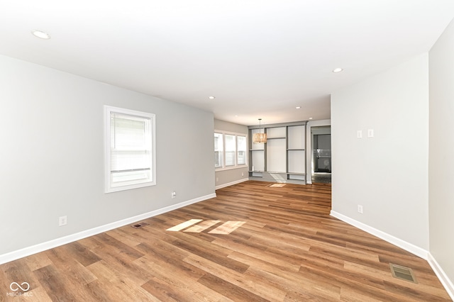 unfurnished living room with light wood-style flooring, recessed lighting, baseboards, and visible vents