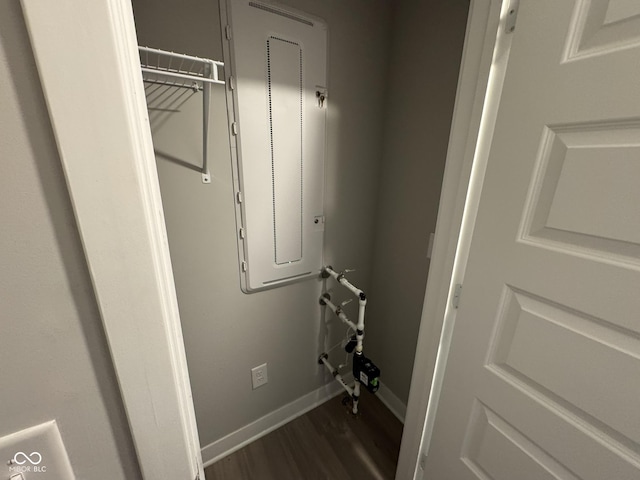 laundry area with dark wood-style floors and baseboards