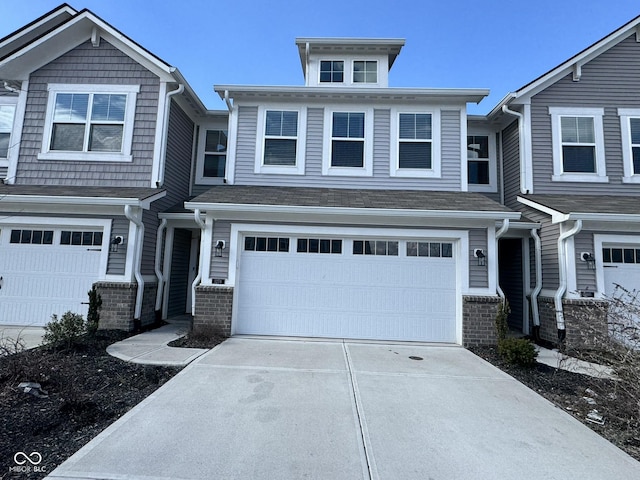 view of front of house with a garage, concrete driveway, and brick siding