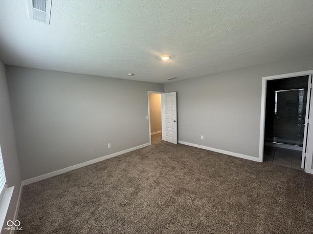 carpeted empty room featuring baseboards, visible vents, and a textured ceiling