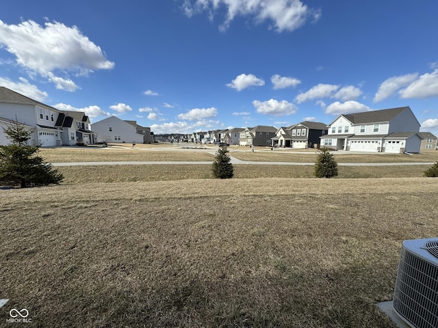 view of yard featuring a residential view and central AC