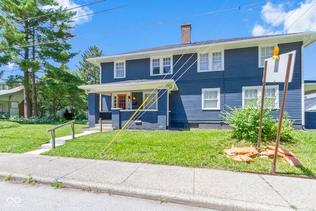 view of front of home featuring a front lawn, a chimney, and a porch