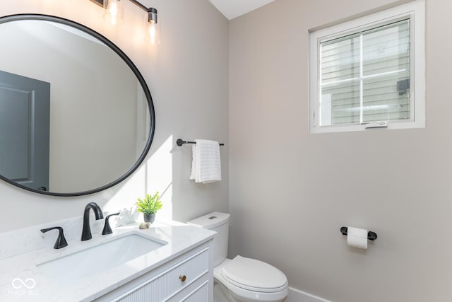 half bathroom featuring vanity and toilet