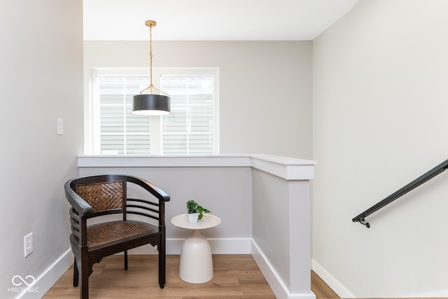 sitting room with baseboards and wood finished floors