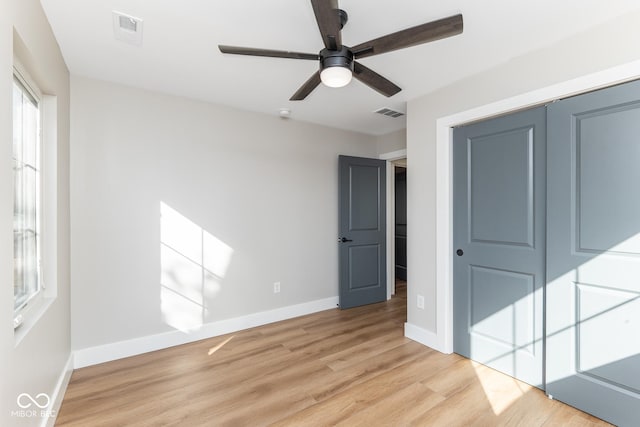 unfurnished bedroom with light wood finished floors, a closet, visible vents, and baseboards