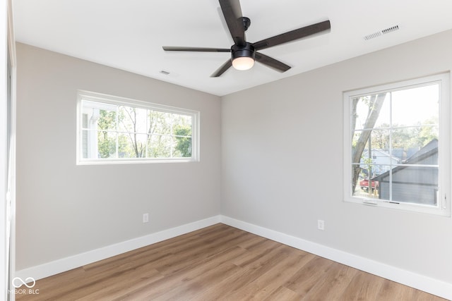 unfurnished room featuring a ceiling fan, light wood-type flooring, visible vents, and baseboards