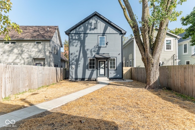 traditional home with board and batten siding and a fenced backyard