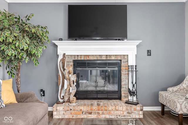 room details with a fireplace, baseboards, and wood finished floors