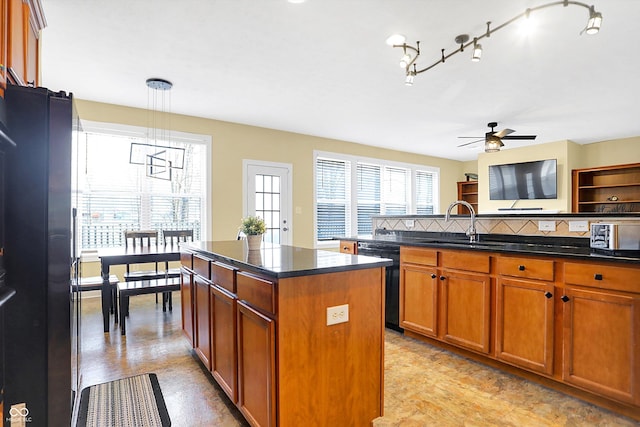 kitchen with a center island, brown cabinets, backsplash, a sink, and black appliances