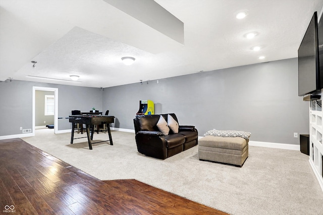 living room with light wood-type flooring, baseboards, a textured ceiling, and recessed lighting