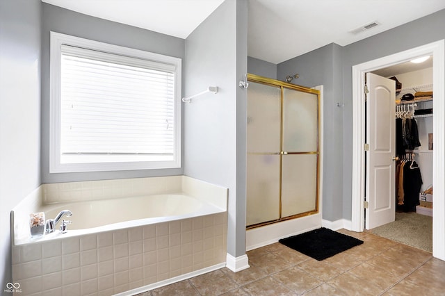 full bathroom featuring a garden tub, a spacious closet, a shower stall, and visible vents