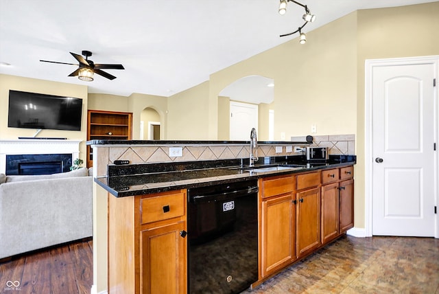 kitchen with black dishwasher, a fireplace, decorative backsplash, open floor plan, and a sink