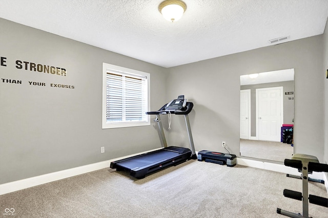 exercise room with baseboards, visible vents, a textured ceiling, and carpet flooring