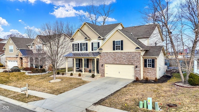 traditional home with driveway, a garage, brick siding, a porch, and a front yard