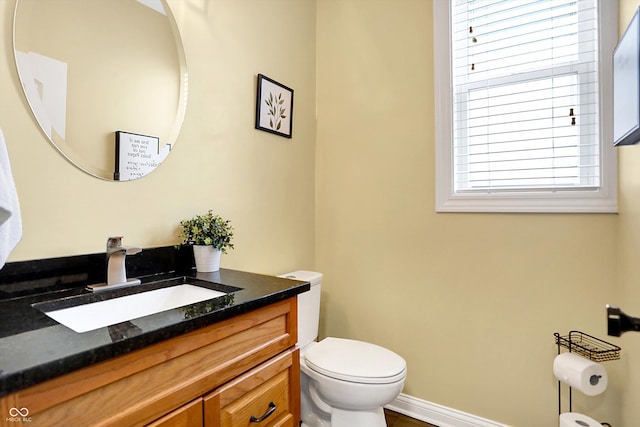 bathroom featuring baseboards, vanity, and toilet