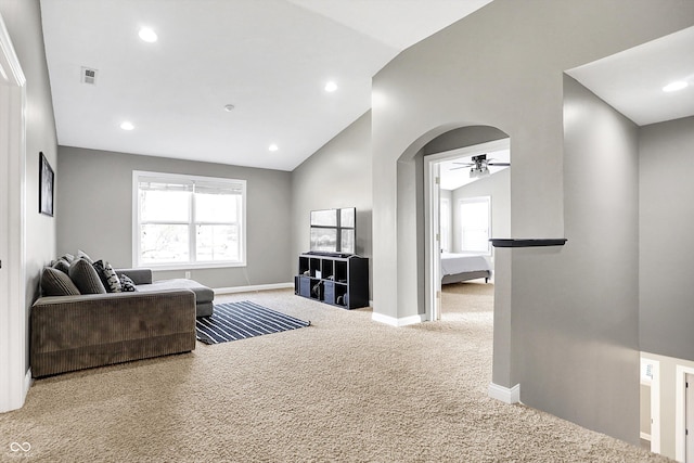 living area featuring visible vents, arched walkways, baseboards, lofted ceiling, and carpet floors