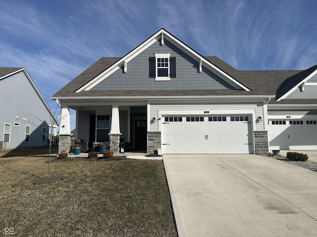 craftsman-style house with stone siding, driveway, and a front lawn