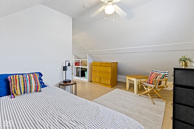 bedroom featuring a ceiling fan, vaulted ceiling, and wood finished floors