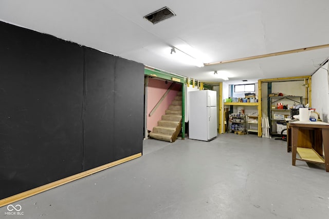 garage with freestanding refrigerator and visible vents