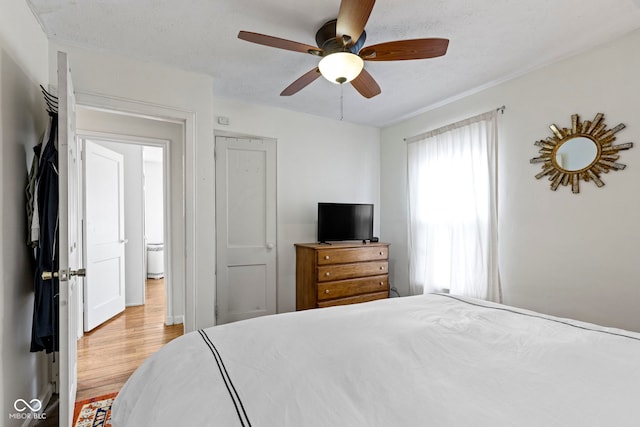 bedroom with a textured ceiling, wood finished floors, and a ceiling fan