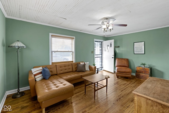 living room featuring crown molding, baseboards, ceiling fan, and wood finished floors