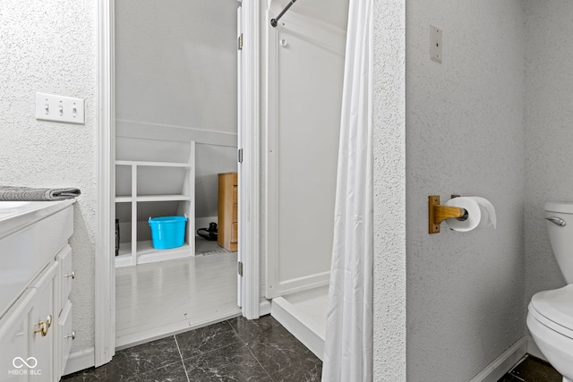 full bathroom featuring marble finish floor, vanity, and toilet