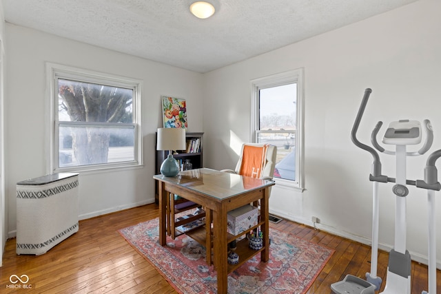 office featuring wood-type flooring, a textured ceiling, and baseboards