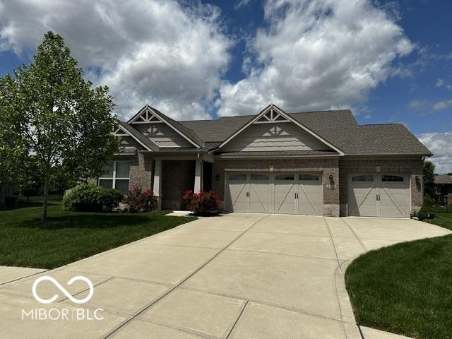 6117 Arctic Cir, Indianapolis, IN 46237 - craftsman-style house with driveway, an attached garage, a front yard, and brick siding