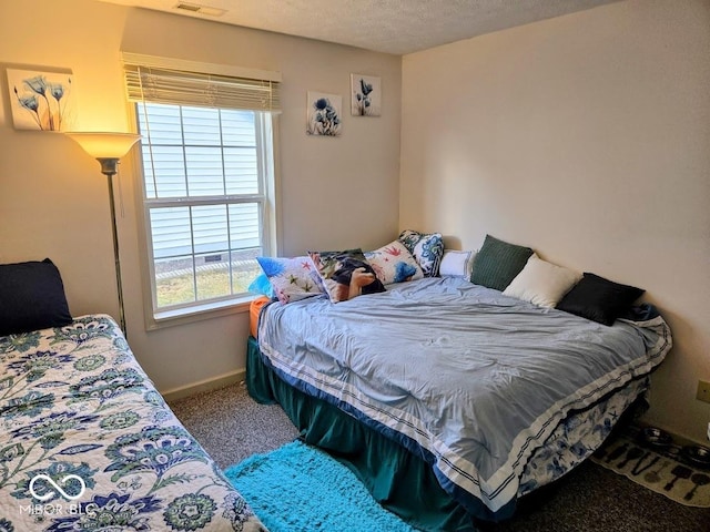 carpeted bedroom with visible vents, baseboards, and a textured ceiling