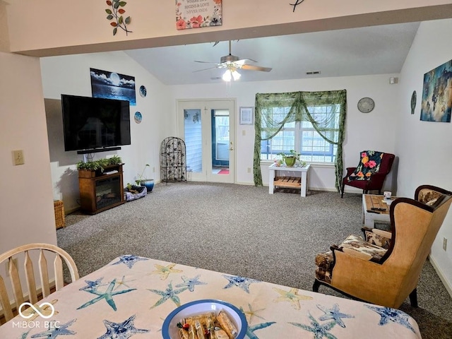 living area with carpet flooring, visible vents, baseboards, vaulted ceiling, and a ceiling fan