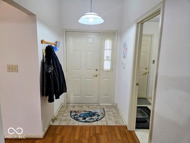 foyer entrance featuring light wood-style flooring and baseboards