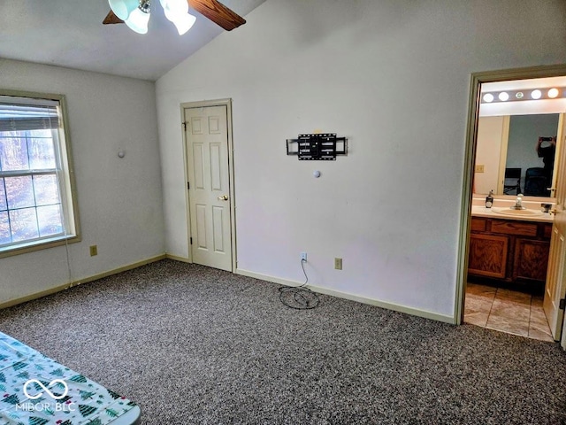 unfurnished bedroom featuring light carpet, vaulted ceiling, and baseboards