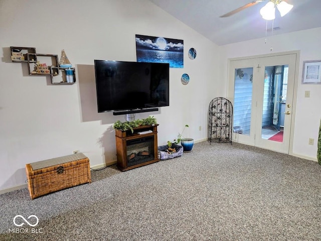 carpeted living area with a ceiling fan, lofted ceiling, and baseboards